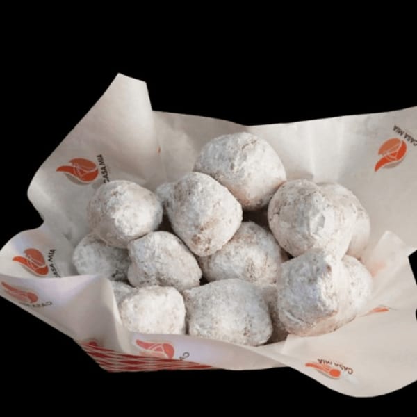 Casa Mia's powdered sugar zeppole, a classic Italian dessert, served in a branded paper-lined basket.