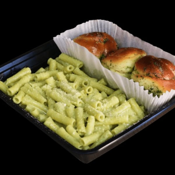 Pesto pasta with grated cheese and three garlic knots in a black takeout container.
